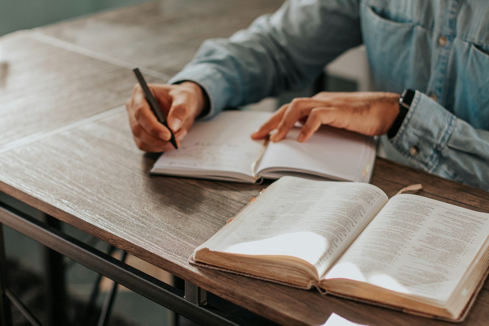 Taking notes beside an open Bible.